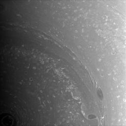 Bright, high-altitude clouds interact with dark, deeper structures near Saturn's south pole. The image was taken with NASA's Cassini spacecraft's wide-angle camera on Aug. 27, 2008.