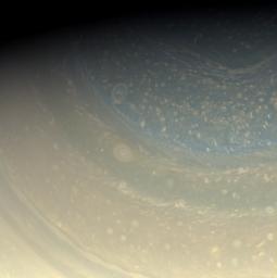 Saturn's north pole is littered with storms, as seen in this color view in hues of pastel yellow of the pole captured by NASA's Cassini spacecraft. A bit of the north polar hexagon is also visible at the upper-right.