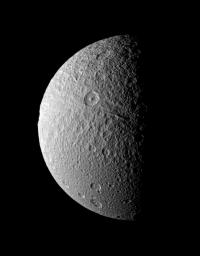 Ithaca Chasma, an enormous rift that stretches from north to south across the face of Tethys, seemingly takes a bite out of the moon's limb in this image from NASA's Cassini spacecraft taken on Dec. 9, 2008.