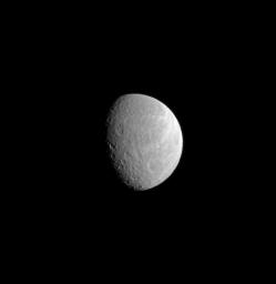 A wide crater dominates the lower right of this image while part of Rhea's brightly lit, wispy terrain can still be seen near the limb of the moon. This image was taken in visible light with NASA's Cassini spacecraft's narrow-angle camera.