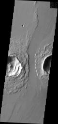 This image from NASA's Mars Odyssey shows a lava channel that cuts between these two craters in Marte Valles.