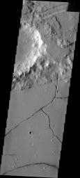 This image from NASA's Mars Odyssey shows a small crater and fractures in the volcanic lava filling the floor of Bernard Crater.
