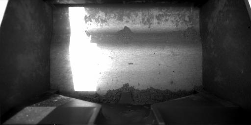 This image, taken by NASA's Phoenix Mars Lander's Robotic Arm Camera on Sol 50, the 50th day of the mission, July 15, 2008, shows material collected in the lander's scoop from the rasping activity on the Martian surface.