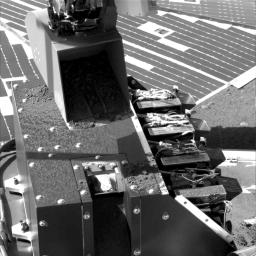 This image was taken by NASA's Phoenix Mars Lander on June 12, 2008. The lander's scoop sprinkled a small amount of soil into a notch in the MECA box where the microscope's sample wheel is exposed.