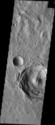This image from NASA's Mars Odyssey shows Terra Sirenum containing a central peak crater that has had minimal modification since formation. The smaller crater on the left is a typical bowl-shaped crater.