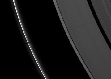 The long shadow of a small moon cuts across Saturn's A ring and thin F ring as the planet approached its August 2009 equinox in this image taken by NASA's Cassini spacecraft.