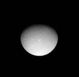 NASA's Cassini spacecraft looks down on the cratered northern leading hemisphere of Saturn's moon, Dione, showing the moon's pockmarked surface.