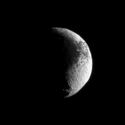 Iapetus shows off its puzzling light and dark terrain in this image captured by NASA's Cassini spacecraft. Lit terrain seen here is on the Saturn-facing side of Iapetus.