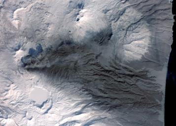 This image acquired by NASA's Terra spacecraft on March 6, 2009, shows early March eruptions of Karymsky volcano on Russia's Kamchatka Peninsula left the usually white snow a gray ashy color. 