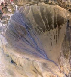 NASA's Terra spacecraft shows vast alluvial fan blossoms across the desolate landscape between two mountain ranges that form the southern border of the Taklimakan Desert in China's XinJiang Province.