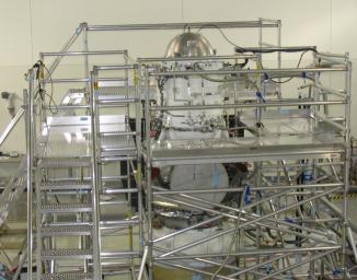 A scaffolding structure built around NASA's Wide-field Infrared Survey Explorer allows engineers to freeze its hydrogen coolant. The WISE infrared instrument is kept extremely cold by a bottle-like tank filled with frozen hydrogen, called the cryostat.