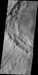 Numerous dark slope streaks mark the rim of this unnamed crater located on the rim of Henry Crater in this image taken by NASA's 2001 Mars Odyssey spacecraft.