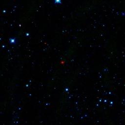 The red smudge at the center of this image is the first comet discovered by NASA's Wide-Field Infrared Survey Explorer, or WISE. The comet is a dusty mass of ice and parades around the sun every 4.7 years.