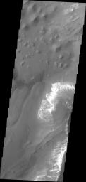 Taken by NASA's 2001 Mars Odyssey spacecraft, this image shows a small portion of the floor of Capri Chasma. Bright layered deposits and dunes are visible.