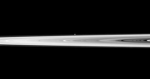 The tiny moon Pandora appears beyond the bright disk of Saturn's rings in this image taken by NASA's Cassini spacecraft. Pandora orbits outside the F ring and, in this image, is farther from Cassini than the rings are.