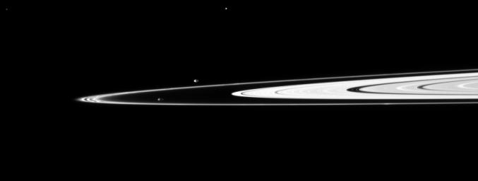 Pandora and Prometheus, the shepherding moons of the F ring, orbit inside and outside the thin ring. The elongated, potato-like shapes of the two moons are both visible in this image taken by NASA's Cassini spacecraft.