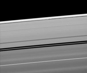 Saturn's moon Daphnis casts a short shadow on the A ring in this image taken by NASA's Cassini spacecraftabout six months after the planet's August 2009 equinox. Daphnis appears as a tiny bright dot in the Keeler Gap of the A ring near the center top.