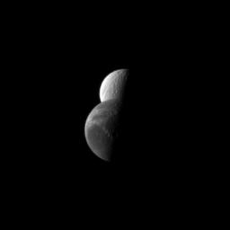 Saturn's moon Dione passes by the moon Tethys in this NASA Cassini spacecraft depiction of a 'mutual event' in which one moon passes close to or in front of another moon.