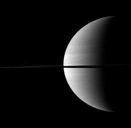 A kingly crescent Saturn rests on the right of this NASA Cassini spacecraft portrait while the moon Mimas appears above the rings on the left. Mimas looks like just a speck of light here but is actually 396 kilometers, or 246 miles, across.