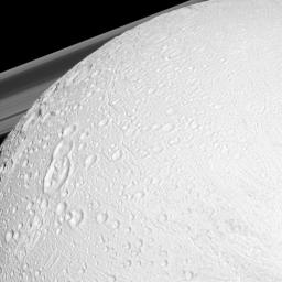 NASA's Cassini spacecraft watches over the northern latitudes of Saturn's geologically active moon Enceladus while the planet's rings peek through in the distance in this snapshot.
