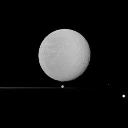 Five moons, dominated by Rhea in the foreground, share NASA's Cassini spacecraft view with Saturn's rings seen nearly edge-on. Also seen here are Dione, Epimetheus, Prometheus, and Tethys.