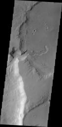 This image captured by NASA's 2001 Mars Odyssey shows a small channel emptying into a deeper crater to the west.