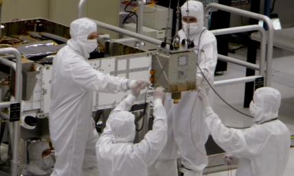 Members of NASA's Mars Science Laboratory team carefully steer the hoisted Chemistry and Mineralogy (CheMin) instrument during its June 15, 2010, installation into the mission's Mars rover, Curiosity.