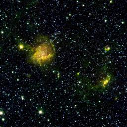 A star-forming region shines from the considerable distance of more than 30,000 light-years away in the upper left of this image from NASA's Spitzer Space Telescope. This image is a combination of data from Spitzer and the Two Micron All Sky Survey.