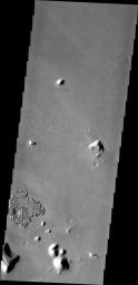 In this image from NASA's Mars Odyssey the majority of the surface appears uniform with a few small hills, the region of fractured blocks sticks out as 'something different,' perhaps remnants of crater ejecta, or an area of a different type of rock.