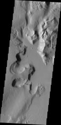 Lycus Sulci is an extremely complex region surrounding the western and northern flanks of Olympus Mons. With a multitude of fault formed cliff faces, dark slope streaks are a common occurrence. This image was captured by NASA's Mars Odyssey.