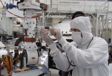Sensors on two finger-like mini-booms extending horizontally from the mast of NASA's Mars rover Curiosity will monitor wind speed, wind direction and air temperature; image taken during installation of the instrument inside a clean room at NASA's JPL.