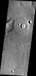 This image from NASA's Mars Odyssey shows a small unnamed channel entering and running along the rim of this unnamed crater in Arabia Terra.