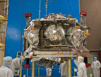 Technicians position NASA's Juno spacecraft on a dolly prior to the start of a round of acoustical testing.