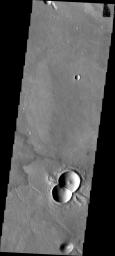This doublet crater was formed when two meteorites impacted at the same time. The shock waves interact to form the straight central rim and the 'wings' of ejecta on the outside of the rims. This image is from NASA's Mars Odyssey.