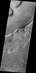 This image from NASA's 2001 Mars Odyssey spacecraft shows several large channels emptying into the eastern Hellas Basin. These southern channels are filled with material today. Whether the material contains volitiles (like ice) is unknown.