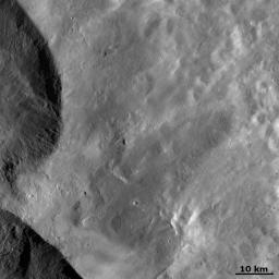 This image from NASA's Dawn spacecraft shows ejecta from two of the large 'Snowman' craters on the left of the image. This ejecta smooths out asteroid Vesta's surface in the rest of the image.