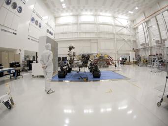 An engineer says goodbye to the Curiosity rover and its powered descent vehicle in the Jet Propulsion Laboratory's Spacecraft Assembly Facility shortly before the spacecraft was readied for shipment to Kennedy Space Center for launch.