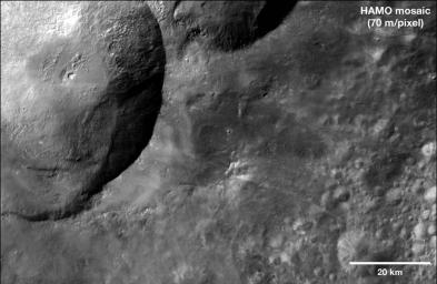 This mosaic from NASA's Dawn spacecraft shows dark material near a series of craters known as the 'snowman' on asteroid Vesta. That ejected material is a complex mixture of components.