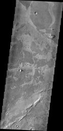 Platy lava flows in Elysium look very different from the thicker flows of the Tharsis region. In this image from NASA's 2001 Mars Odyssey spacecraft, the darker plates are separated by lighter material and some edges 'match-up' like puzzle pieces.