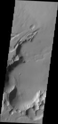 This image from NASA's 2001 Mars Odyssey spacecraft shows Pavonis Chasma on Mars, a collapsed region on the northeastern flank of Pavonis Mons. The chasma is aligned with the trend of the three Tharsis volcanoes, of which Pavonis Mons is the central one.