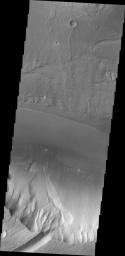 At the base of this slope is a fan-shaped deposit of the slope forming material on Mars. The channel that the fan rests upon is Kasei Valles in this image as seen by NASA's 2001 Mars Odyssey spacecraft.