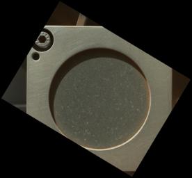 This image taken by the MAHLI camera shows a sample of basaltic rock from a lava flow in New Mexico serves as a calibration target carried on the front of NASA's Mars rover Curiosity for the rover's Canadian-made APXS instrument.