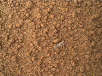 This image from NASA's Mars rover Curiosity shows a small bright object on the ground beside the rover at the 'Rocknest' site. The rover team has assessed this object as debris from the spacecraft, possibly from the events of landing on Mars.