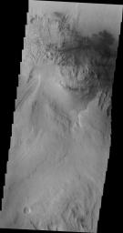 Continuing westward, this image from NASA's Mars Odyssey spacecraft shows Mt. Sharp just east of the highest peak of the deposit. The dark material near the top of the image is likely sand. This image shows the dark material on the floor and on Mt. Sharp.