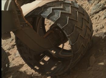 The left-front wheel of NASA's Curiosity Mars rover shows dents and holes in this image taken by the MAHLI camera, which is mounted at the end of Curiosity's robotic arm.
