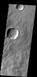 Several channels are located on the flank of Hecates Tholus. In this image captured by NASA's 2001 Mars Odyssey spacecraft, one of those channels enters a crater, creating a deposit on the floor of the crater.