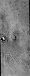 This image captured by NASA's 2001 Mars Odyssey spacecraft shows ejecta pattern around this northern plains crater on Mars, termed 'butterfly' for its similarity to butterfly wings. 