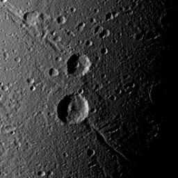 Cassini captures a crater duo (Italus on ancient trough called Petelia Fossae, and Caieta, atop Helorus Fossa) on Saturn's moon Dione that is superimposed on older, linear features.