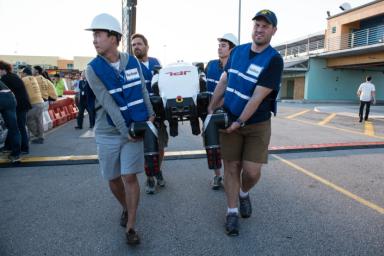 Engineers from NASA's Jet Propulsion Laboratory carry RoboSimian, a robot developed at JPL, at the DARPA Robotics Challenge Trials in Florida in December 2013.