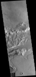 Lava flows of Daedalia Planum can be seen at the top and bottom portions of this image from NASA's 2001 Mars Odyssey spacecraft. The ridge and linear depression in the central part of the image are part of Mangala Fossa, a fault bounded graben.